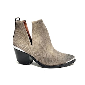 May include: A grey ankle boot with a textured pattern. The boot features a pointed toe with a silver metal cap, a black heel, and a V-shaped cut on the side. The boot has a pull tab at the back.