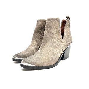 May include: A pair of grey ankle boots with a textured, snake-like pattern. The boots have a pointed toe with a silver metal cap, a side cut-out, and a black block heel.