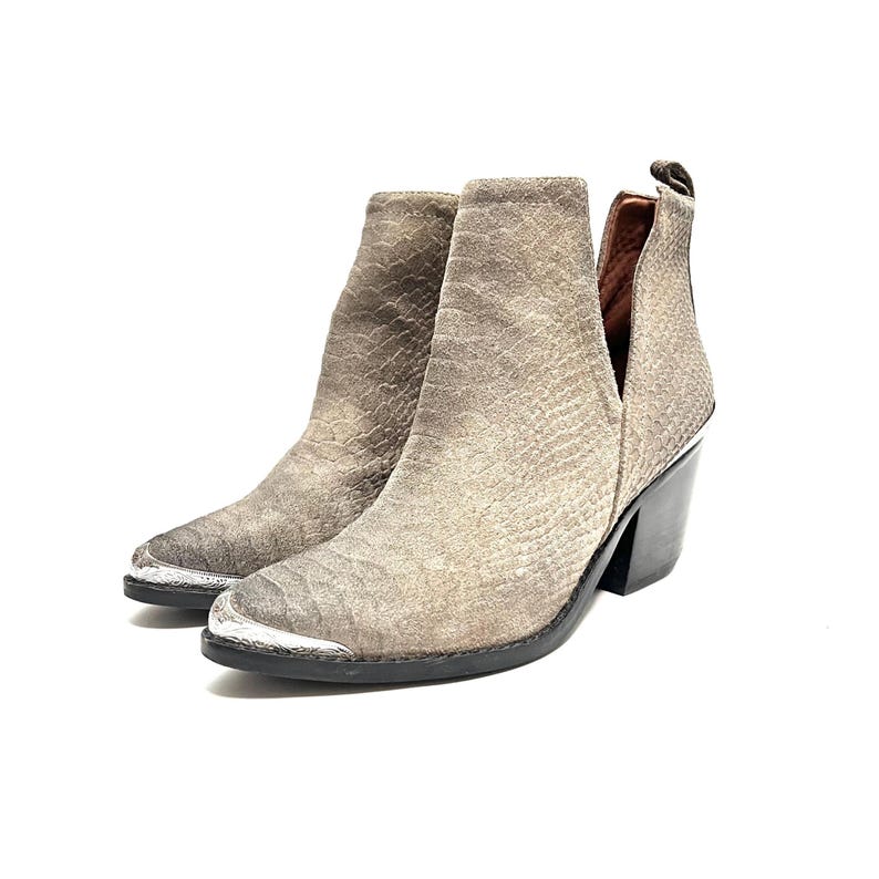 May include: A pair of grey ankle boots with a textured, snake-like pattern. The boots have a pointed toe with a silver metal cap, a side cut-out, and a black block heel.