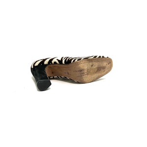 Pode incluir: Sapatos de salto alto com estampa de zebra em preto e branco, com salto preto e sola de couro marrom. A sola &eacute; etiquetada com "Donadio" e "Made in China".