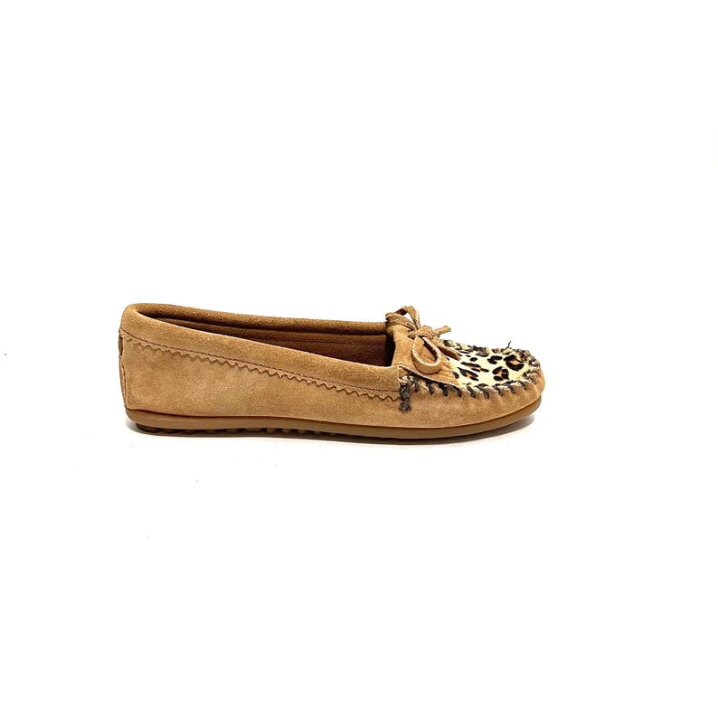 Puede incluir: Mocasines de ante marr&oacute;n claro con un detalle de estampado de leopardo en la parte posterior. Los mocasines tienen una suela de cuero y un detalle de costura decorativo.