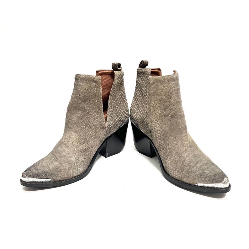May include: A pair of grey ankle boots with a snakeskin pattern. The boots have a pointed toe with a silver metal cap, a black heel, and a V-shaped cut on the side. The boots are made of suede.