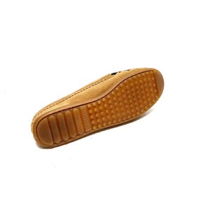 Puede incluir: La suela de un mocas&iacute;n de cuero marr&oacute;n con una suela de goma texturizada. La suela tiene una serie de peque&ntilde;os bultos y crestas para la tracci&oacute;n.