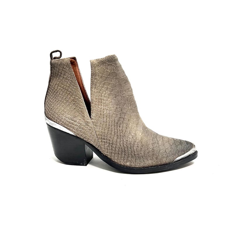May include: A grey ankle boot with a textured pattern. The boot features a pointed toe with a silver metal cap, a black heel, and a V-shaped cut on the side. The boot has a pull tab at the back.