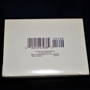 Peut inclure: Une bo&icirc;te blanche avec un code-barres et le texte "05749", "1996 Turner Entertainment Co. All Rights Reserved", "Mid. for Hallmark Cards, Inc., K.C., MO 64141", "Made in Thailand", et "QX5749".