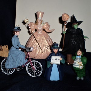 Peut inclure: Un ensemble de sept d&eacute;corations de No&euml;l sur le th&egrave;me du Magicien d'Oz. Les d&eacute;corations repr&eacute;sentent des personnages du film, notamment Dorothy, la M&eacute;chante Sorci&egrave;re de l'Ouest, le Magicien et l'&Eacute;tain. Les d&eacute;corations sont en porcelaine et peintes dans des couleurs vives.