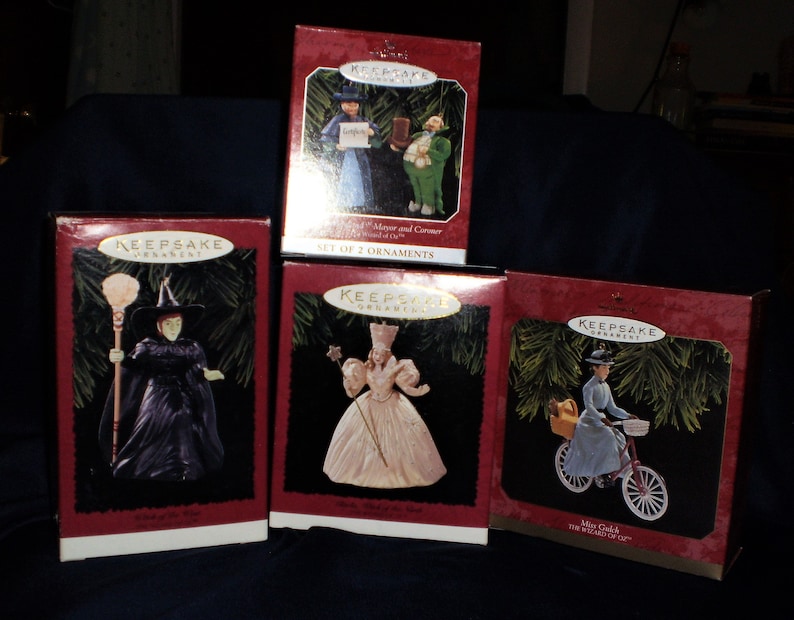 Peut inclure: Ensemble de cinq ornements de No&euml;l sur le th&egrave;me du Magicien d'Oz dans leurs bo&icirc;tes d'origine. Les ornements repr&eacute;sentent Dorothy, la M&eacute;chante Sorci&egrave;re de l'Ouest, Glinda la Bonne Sorci&egrave;re, et le Lion et l'&Eacute;tain L&acirc;che.