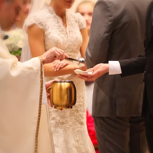 couple having rings blessed using clarey clayworks wedding bowl