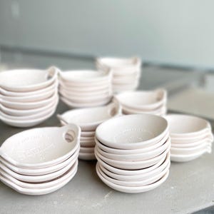8 short stacks of ceramic bowls sit on top of a kiln.