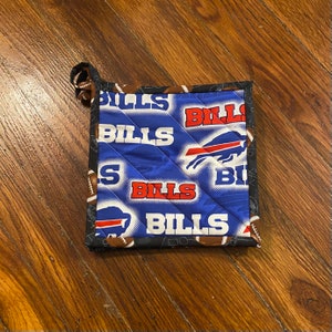 May include: Blue and black quilted pot holder with the words "Bills" repeated and a blue buffalo logo.