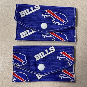 May include: Two blue fabric card holders with white text that reads "BILLS" and a red, white, and blue buffalo logo. Each holder has a white button closure.
