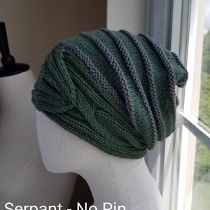 May include: A green and gray knitted beanie with a cable knit pattern. The beanie is on a white mannequin head. "Serpant - No Pin" is written below the mannequin.
