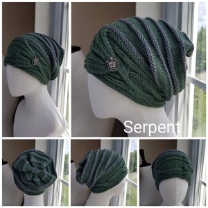 May include: Green and gray knit beanie with a silver emblem that says "Serpent". The beanie is on a mannequin head.