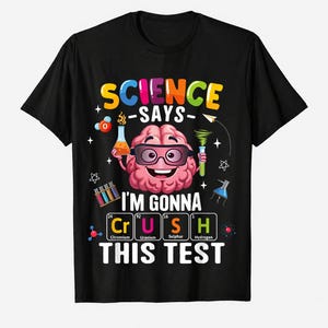 Può includere: T-shirt nero con una grafica colorata raffigurante un cervello sorridente con occhiali, circondato da illustrazioni scientifiche. Il testo recita "SCIENCE SAYS I'M GONNA CRUSH THIS TEST". Un design divertente ed educativo.