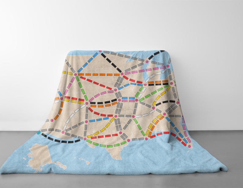 May include: A blue and beige throw blanket with a map of the United States printed on it. The map shows the major cities and highways in the country. The blanket is made of soft, comfortable fabric and is perfect for snuggling up on the couch.
