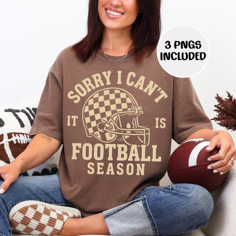 K&ouml;nnte beinhalten: Braunes T-Shirt mit dem Text "SORRY I CAN'T IT IS FOOTBALL SEASON" und einer Footballhelm-Grafik. Das Shirt hat eine neutrale Farbe und eine lockere Passform. Ein Football wird gehalten. Der Text "3 PNGS INCLUDED" ist ebenfalls enthalten.