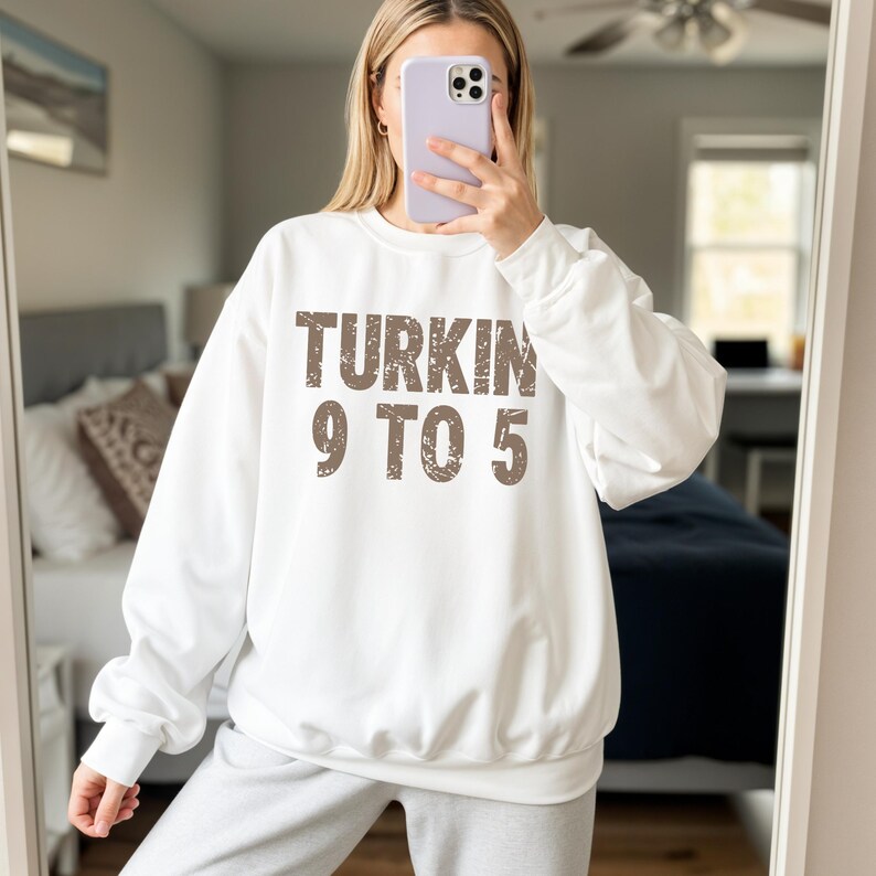 Pu&ograve; includere: Felpa bianca con la scritta "TURKIN 9 TO 5" in lettere marroni sbiadite. La felpa &egrave; a girocollo e sembra essere realizzata in un materiale morbido. Lo stile generale &egrave; casual e confortevole.