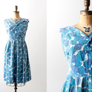 50 blue floral dress. summer. 1950s flower print swing dress. pleated skirt. Bows. Sleeveless.