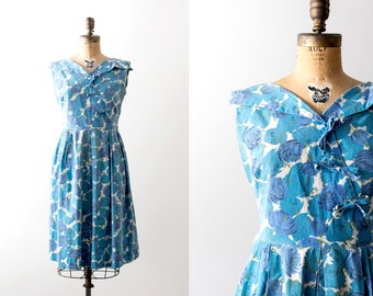 50 blue floral dress. summer. 1950s flower print swing dress. pleated skirt. Bows. Sleeveless.