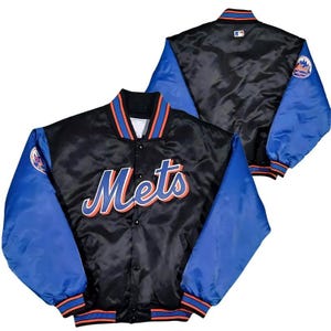 May include: A black satin baseball jacket with blue sleeves and the word "Mets" in orange and white lettering on the front. The jacket has a zipper closure and a ribbed collar, cuffs, and waistband.