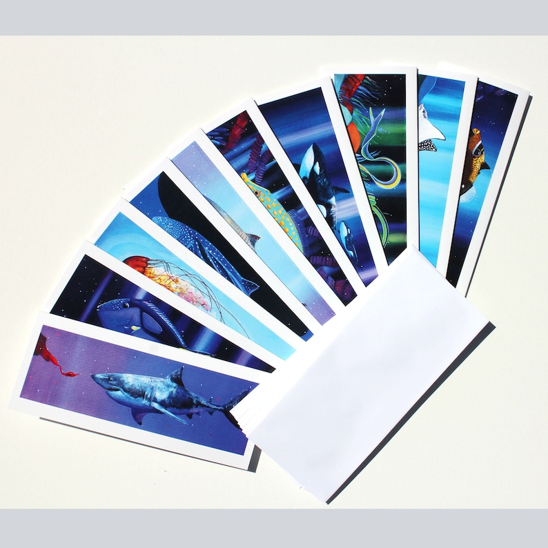 May include: A set of ten greeting cards featuring colorful illustrations of various sea creatures, including a shark, a jellyfish, and a stingray. The cards are arranged in a fan shape and are ready to be sent to loved ones.