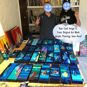 May include: A collection of colorful, abstract acrylic paintings on wooden panels. The paintings feature a variety of subjects, including fish, seashells, and other marine life. The text "Your Card Image Is From Original Art Work Acrylic Paintings Seen Here!" is visible in the image.