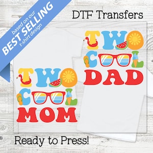 Pode incluir: Duas camisetas brancas com designs coloridos de verão. Uma diz "TWO COOL MOM" e a outra "TWO COOL DAD" em vermelho, azul, amarelo e verde. O texto "Ready to Press!" está na parte inferior. DTF Transfers.