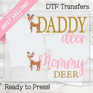 May include: White t-shirts with deer graphics and text. One shirt says "Daddy Deer" in gold, another says "Mommy Deer" in pink, and the third has a deer graphic. The image also includes the text "Best Selling" and "Ready to Press!"