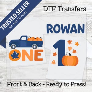 May include: Two white t-shirts with fall-themed designs. One shirt features a blue truck carrying pumpkins and the word "ONE". The other shirt has the number "1", a pumpkin, and leaves. Text on the image says "DTF Transfers" and "Front & Back - Ready to Press!"
