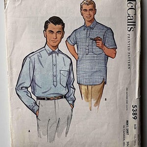 May include: Vintage McCall's printed pattern for a men's shirt, featuring illustrations of two shirt designs. The pattern cover shows a long-sleeved light blue shirt and a short-sleeved blue and white checkered shirt. The pattern number is 5389, size 15-15 1/2.