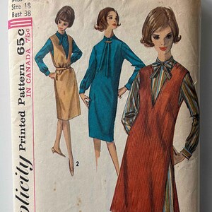 May include: Vintage Simplicity sewing pattern for a dress, size 18, bust 38. The pattern shows three different styles of dresses, one in brown, one in blue, and one in red. The pattern is labeled "Simplicity Printed Pattern 65c".
