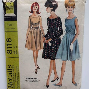 May include: Vintage McCall's sewing pattern for Misses' and Junior dresses. The pattern envelope features illustrations of three dresses in various styles, with the text "It's Young Fashion!" and "Misses' and Junior Dress with Transfer for Smocking."