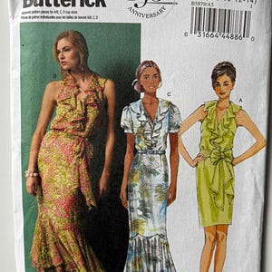 May include: A Butterick sewing pattern envelope, B5879, featuring illustrations of three different dresses. The dresses are in various styles, including a wrap dress and a dress with ruffles. The envelope includes the text "150th Anniversary".