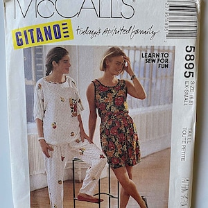 May include: A sewing pattern for a dress and pants. The pattern is for sizes 6 and 8, and is for an extra small size. The pattern is from McCall's and is called Gitano. The pattern is for a dress with a floral print and pants with a polka dot print.
