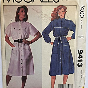 May include: A sewing pattern for a dress with two different styles. The pattern is for size 14 and is called McCall's 9413. The dress on the left is white and has a button-down front. The dress on the right is blue denim and has a tie belt.