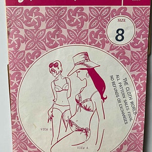 May include: A vintage sewing pattern for a swimsuit with two different views. The pattern is from Patterns Pacifica and is size 8. The pattern is pink and white with a floral design. The text on the pattern reads "The Cloth World, All Pattern Sales Final, No Refunds or Exchanges."