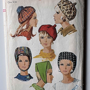 May include: A Simplicity 7326 sewing pattern envelope featuring illustrations of six different headwear styles. The designs include a pom-pom beanie, a leopard print beret, a solid red beret, a patterned hood, a green headscarf, and a polka dot headscarf.