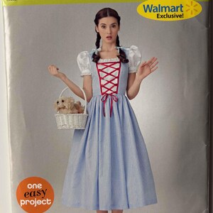 May include: Simplicity sewing pattern 0903 for a blue and white gingham dress with red lacing, white sleeves, and a matching basket. The pattern is marked as a Walmart Exclusive.