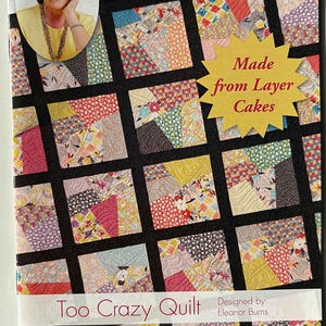 May include: A book cover titled "Quilt in a Day" featuring a colorful quilt design. The quilt is made of squares with various fabric patterns. Text on the cover includes "Made from Layer Cakes" and "Too Crazy Quilt".