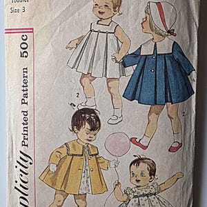 May include: Vintage Simplicity sewing pattern for a toddler size 3. The pattern envelope features illustrations of children in dresses and coats. The envelope is off-white with the text "3843 Toddler Size 3 Printed Pattern 50c" in black and red.