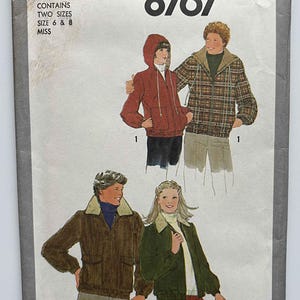 May include: Simplicity pattern 8767 featuring illustrations of jackets with hoods and collared jackets. The pattern includes two sizes, 6 and 8. The jackets are shown in various colors, including red, brown, green, and plaid.