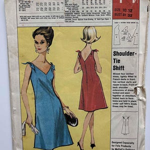 May include: Vintage sewing pattern for a shoulder-tie shift dress. The pattern features illustrations of the dress in blue and red, with a V-neck and tie detail at the shoulders. The pattern includes size and fabric requirements.