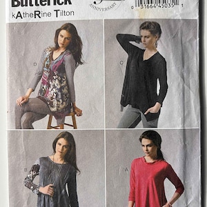 May include: A white ceramic mug with a black handle and the text "But First, Coffee" in a black, handwritten-style font. The mug is on a white surface.