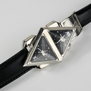 Pu&ograve; includere: Un orologio da polso triangolare argentato con due quadranti neri e un cinturino in pelle nera.