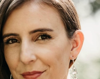 May include: A pair of drop earrings featuring two stacked clear rectangular stones connected by silver-toned metal links, ending in a delicate silver-toned chain tassel. The earrings are worn on silver-toned ear wires.