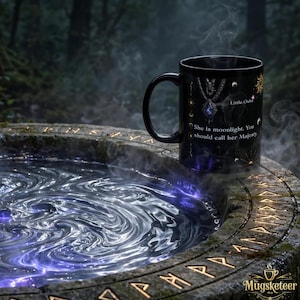 May include: A black ceramic mug featuring a graphic of a pendant necklace, celestial symbols, and the text 'Little Osha' and 'She is moonlight. You should call her Majesty.' The mug is positioned on a stone basin filled with swirling, glowing liquid.