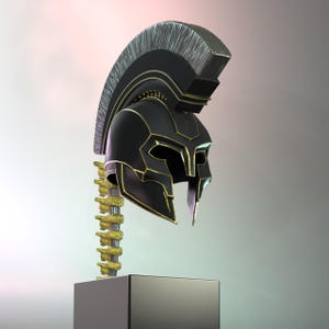 May include: A black and gold Spartan helmet with a silver crest, presented on a black plinth. The helmet has detailed gold accents and is supported by a gold-coloured structure.