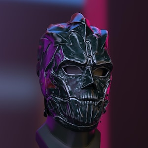 Puede incluir: Una máscara metálica verde oscuro con un diseño de calavera. La máscara presenta placas remachadas, una nariz prominente y cuencas de los ojos. La estética general sugiere un tema futurista o de fantasía.