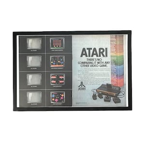 Könnte beinhalten: Ein alter Atari-Werbedruck mit einem Stapel bunter Spielkassetten, einer Konsole und vier Joysticks. Die linke Seite zeigt vier Fernsehbildschirme, die leere Bildschirme mit Atari-Spielgrafiken vergleichen.