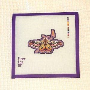 May include: A purple needlepoint canvas with a colorful butterfly design. The canvas has a purple border and the text "Piper Lou NP" in the bottom left corner.